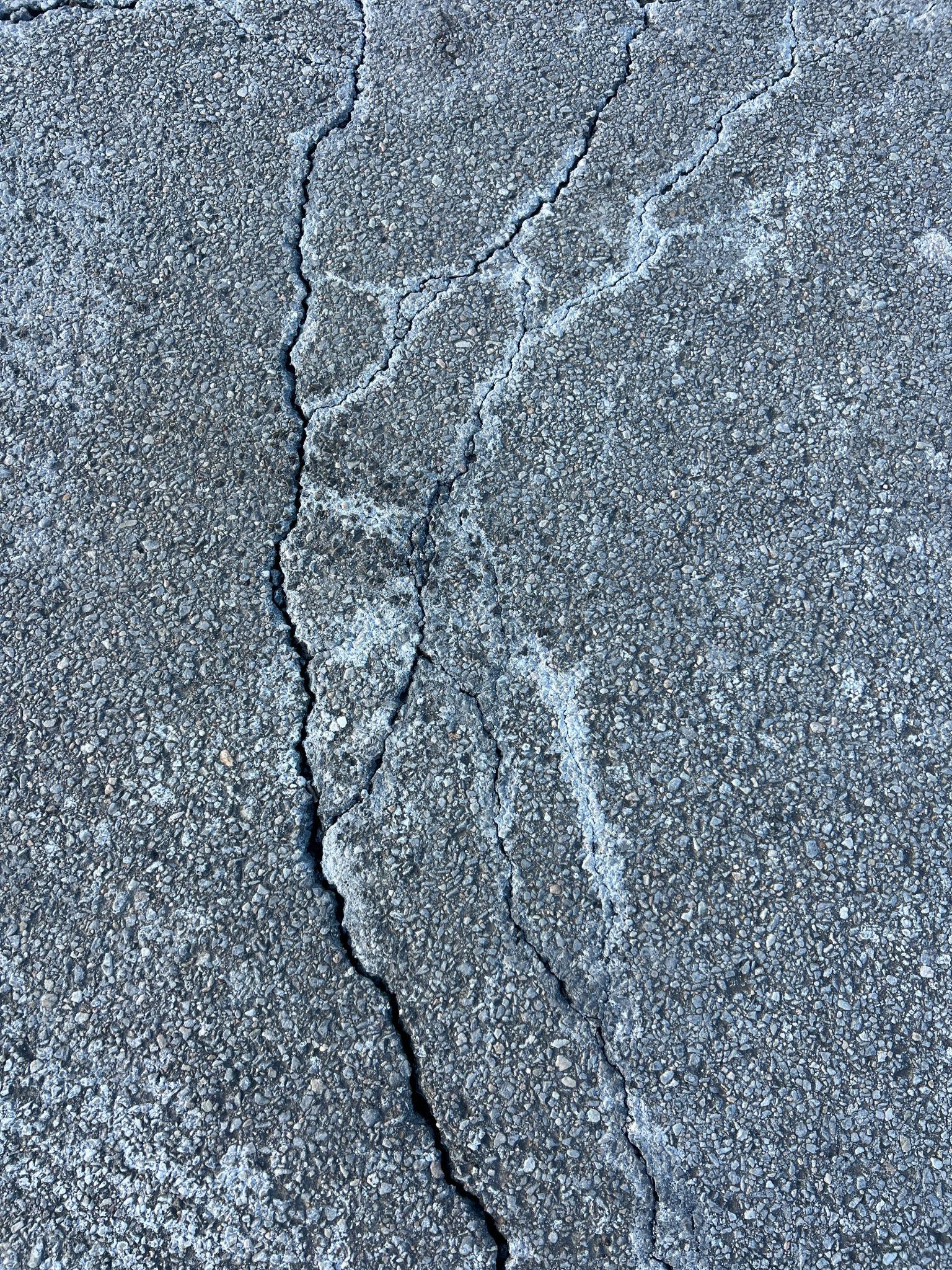 Fresh asphalt repair section in Edmonton parking lot